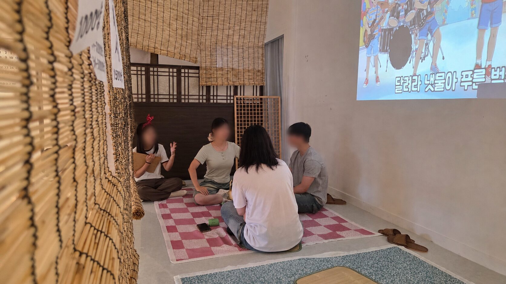 참가자들이 자리에 둘러앉아 대화하는 모습. 얼굴은 익명화 처리됨